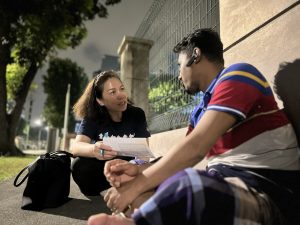 migrant worker being spoke to by a female church member